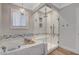 Elegant bathroom featuring a walk-in shower, and soaking tub with chandelier lighting at 925 Alan Shepard St, Las Vegas, NV 89145