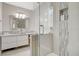 This well-lit bathroom offers modern features such as a vanity, decorative mirror, a glass enclosed shower with tiled walls at 925 Alan Shepard St, Las Vegas, NV 89145