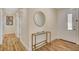 Bright entryway features hardwood flooring, modern console table and decorative round mirror at 925 Alan Shepard St, Las Vegas, NV 89145
