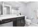 The bathroom features modern vanity with dark cabinets, a large mirror, and a shower-tub combo at 9730 Cluny Ave, Las Vegas, NV 89178