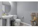 Comfortable half bath featuring a pedestal sink, toilet, and modern finishes at 9730 Cluny Ave, Las Vegas, NV 89178