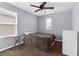 This bedroom has a ceiling fan, carpeted floors, and a window to let in natural light at 9730 Cluny Ave, Las Vegas, NV 89178