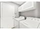 Functional laundry room with a white washer and dryer and plenty of storage in the upper cabinets at 981 Leadville Meadows Dr, Henderson, NV 89052