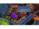 Aerial shot of a backyard with an illuminated pool and landscaped garden and patio areas at 9906 Stiges St, Las Vegas, NV 89178