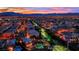 A beautiful aerial view of a residential neighborhood during a vivid sunset with illuminated houses and manicured landscaping at 9906 Stiges St, Las Vegas, NV 89178