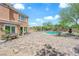 Backyard features a pool, water feature, and patio furniture with blue sky at 9906 Stiges St, Las Vegas, NV 89178
