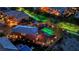 An aerial shot showcases a backyard featuring a sparkling pool, lush greenery, ambient lighting, and privacy fencing at 9906 Stiges St, Las Vegas, NV 89178