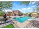 Beautiful backyard with pool, waterfall feature and seating area with blue sky at 9906 Stiges St, Las Vegas, NV 89178