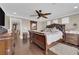 Spacious bedroom features a wooden sleigh bed, ceiling fan, and hardwood floors at 9906 Stiges St, Las Vegas, NV 89178