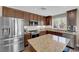 Beautiful kitchen featuring stainless steel appliances, custom cabinets, stylish countertops, and a functional center island at 9906 Stiges St, Las Vegas, NV 89178