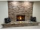 Beautiful stone fireplace with a cozy fire, granite hearth, and decorative pillows at 1006 Bel Air Cir, Las Vegas, NV 89109