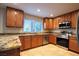 Well-lit kitchen with granite counters, wood cabinetry, stainless steel appliances, and tiled backsplash at 1006 Bel Air Cir, Las Vegas, NV 89109
