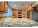Spacious kitchen with granite counters, wood cabinetry, stainless steel appliances, and island seating at 1006 Bel Air Cir, Las Vegas, NV 89109