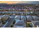 Nighttime aerial view showing a vibrant community with backyard patios and the city skyline at 10140 Magnolia Creek St, Las Vegas, NV 89141