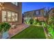 Beautiful backyard featuring artificial turf, brick pavers, decorative clock, and manicured landscaping at 10140 Magnolia Creek St, Las Vegas, NV 89141