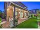 Charming covered patio with string lights, brick pavers, and lush synthetic grass creates an inviting outdoor space at 10140 Magnolia Creek St, Las Vegas, NV 89141