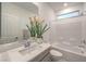 Bright bathroom featuring a tub with tile surround, vanity with sink, and a neutral color scheme at 10140 Magnolia Creek St, Las Vegas, NV 89141