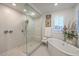 Bathroom featuring a glass-enclosed shower and soaking tub with natural light from windows at 10140 Magnolia Creek St, Las Vegas, NV 89141