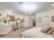 Bedroom showcasing a queen bed with access to ensuite bathroom, chandelier, and decor at 10140 Magnolia Creek St, Las Vegas, NV 89141