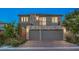 Contemporary two-story home featuring a three-car garage and stone accents, plus a small balcony at 10140 Magnolia Creek St, Las Vegas, NV 89141