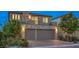 A modern two-story home with a stone accent facade, balcony, and a two-car garage at 10140 Magnolia Creek St, Las Vegas, NV 89141