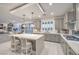 Modern kitchen with a large island, bar stool seating, gray cabinets, and view to the living space at 10140 Magnolia Creek St, Las Vegas, NV 89141