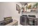 Laundry room featuring modern front loading washer and dryer and decorative storage at 10140 Magnolia Creek St, Las Vegas, NV 89141
