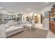 Spacious living room showcasing an open layout with white furnishings and views of the kitchen and dining areas at 10140 Magnolia Creek St, Las Vegas, NV 89141