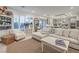 Comfortable living room with white furnishings, shutters, and an open view of the kitchen at 10140 Magnolia Creek St, Las Vegas, NV 89141