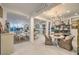 Open-concept living space with white tile floors and stylish furnishings, plus a kitchen in the background at 10140 Magnolia Creek St, Las Vegas, NV 89141