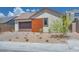 Charming single-story home featuring a brown garage door, a wood panel accent, and desert landscaping at 1021 Golden Summit Dr, Las Vegas, NV 89138