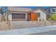 Charming single-story home featuring a brown garage door, a wood panel accent, and desert landscaping at 1021 Golden Summit Dr, Las Vegas, NV 89138