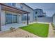 Backyard featuring a covered patio, artificial grass, stone landscaping, and a sliding glass door at 10448 Smokey Mariposa, Las Vegas, NV 89166