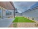 Modern backyard with artificial grass, neutral stone, and a covered patio, perfect for outdoor living at 10448 Smokey Mariposa, Las Vegas, NV 89166