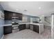 Modern kitchen features stainless steel appliances, dark cabinets, and a breakfast bar at 106 Basketflower Ct, Las Vegas, NV 89183