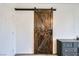 Rustic wooden barn door with black hardware adds character to the bedroom at 10650 Sariah Skye Ave, Las Vegas, NV 89166