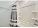 Bright bathroom features a tub with a shower and sleek white tile at 10650 Sariah Skye Ave, Las Vegas, NV 89166