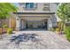 Exterior view of a two car garage with a brick paver driveway and manicured landscaping at 10650 Sariah Skye Ave, Las Vegas, NV 89166