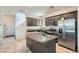 Well-lit kitchen with a granite island and stainless steel refrigerator at 10650 Sariah Skye Ave, Las Vegas, NV 89166