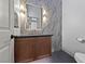 Stylish powder room with dark wood vanity, unique herringbone flooring, and decorative light fixtures at 10814 Franklin Hills Ave, Las Vegas, NV 89135