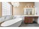 A spacious bathroom features a soaking tub, double vanities, and unique lighting, offering a spa-like retreat at 10814 Franklin Hills Ave, Las Vegas, NV 89135