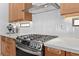 Modern kitchen with stainless steel gas range, marble countertops and light wood cabinetry at 10814 Franklin Hills Ave, Las Vegas, NV 89135