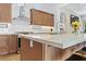 Marble countertop island with seating in open kitchen with stainless appliances and light wood cabinetry at 10814 Franklin Hills Ave, Las Vegas, NV 89135
