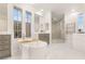Bright bathroom with a soaking tub, dual vanities, a glass shower and contemporary fixtures at 11271 Winter Cottage Pl, Las Vegas, NV 89135