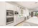 Gourmet kitchen with custom white cabinetry, stainless steel appliances, and adjacent breakfast bar at 11271 Winter Cottage Pl, Las Vegas, NV 89135