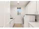 Bright laundry room with sink, counter space, washer, dryer, and window with wooden blinds at 11271 Winter Cottage Pl, Las Vegas, NV 89135