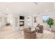 Elegant living room with a fireplace, wood floors, large windows and modern furnishings at 11271 Winter Cottage Pl, Las Vegas, NV 89135