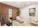 Bright office with wood-paneled wall, comfortable seating, and natural light from large window at 11271 Winter Cottage Pl, Las Vegas, NV 89135