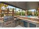 Gourmet outdoor kitchen featuring stainless steel appliances and granite counters, perfect for poolside entertaining at 11271 Winter Cottage Pl, Las Vegas, NV 89135
