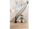Elegant curved staircase with wrought iron railing and decorative chandelier at 11271 Winter Cottage Pl, Las Vegas, NV 89135